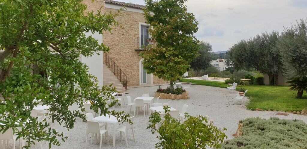 Uliwood guest house in Caltanissetta, Sicily, with garden seating under the trees