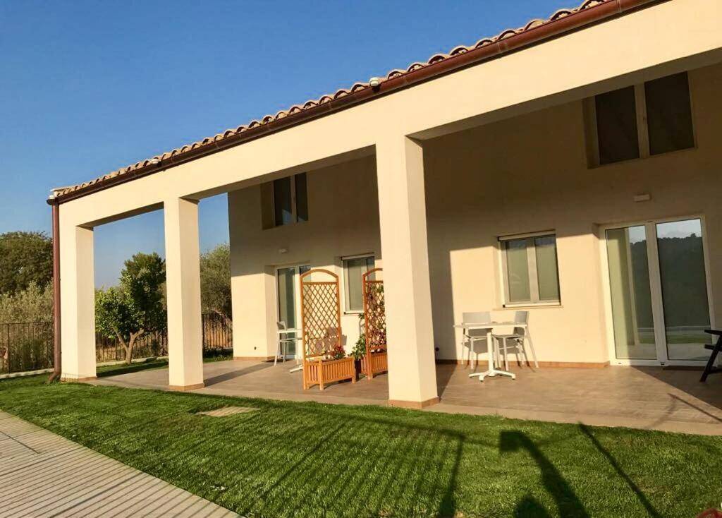 Covered terrace and lawn at Uliwood in Caltanissetta